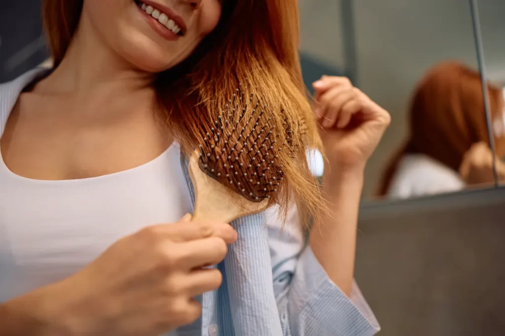 close up of woman brushing hair in the bathroom utc