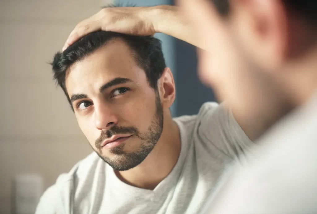 man worried for alopecia checking hair for loss utc