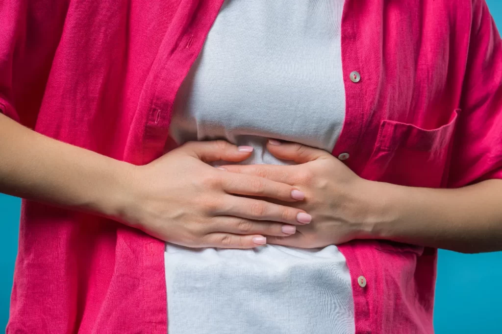 young woman squeezing belly with hands abdominal utc